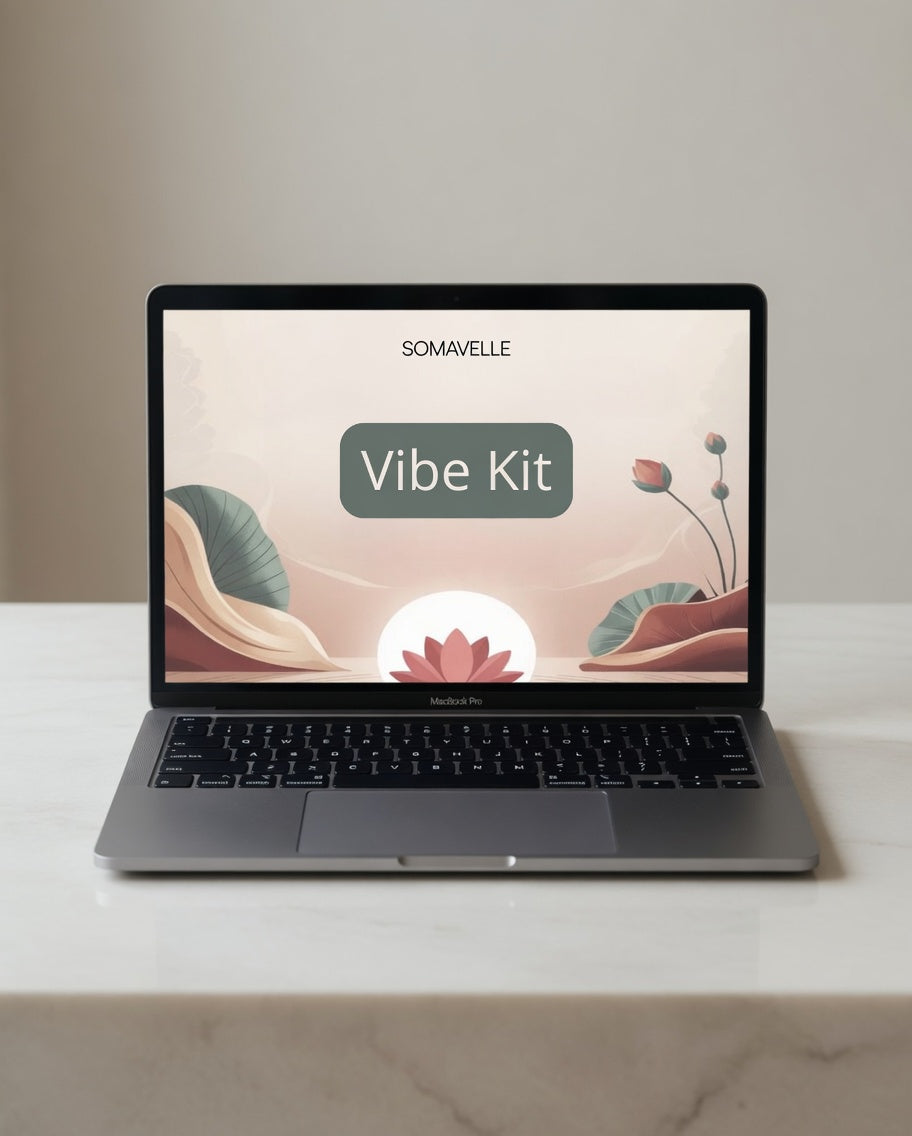 Laptop on a marble surface with a 'Vibe Kit' screen displaying 'SOMAVELLE'.